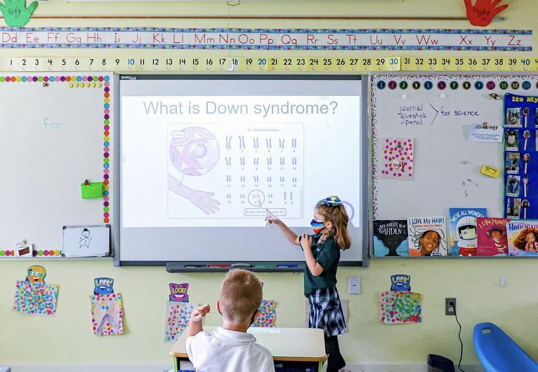 Photo of child giving presentation on Down syndrome in a classroom.