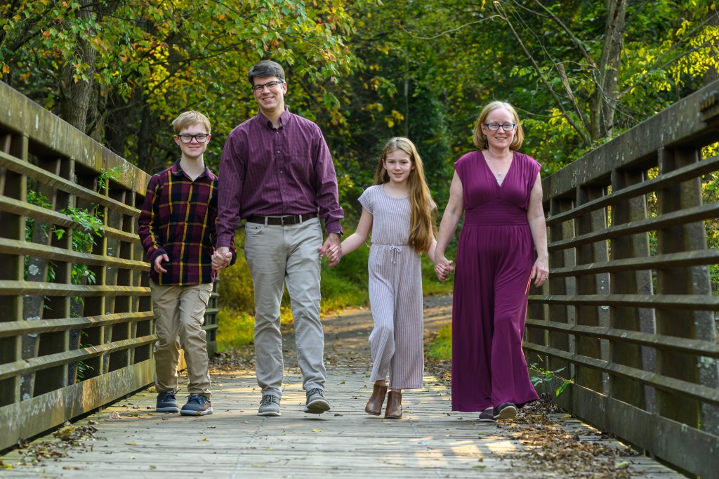 family of four walking on a bridge