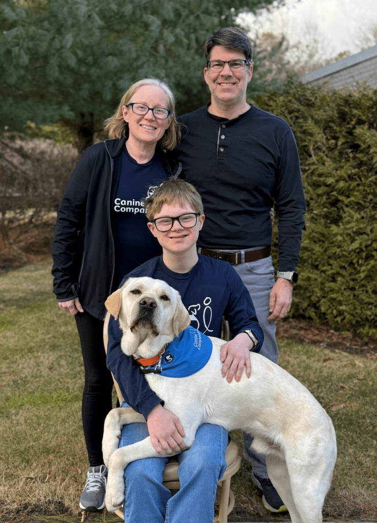 woman, man, and boy with dog on his lap